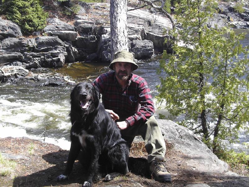 A person sitting on a rock next to a dog

AI-generated content may be incorrect.